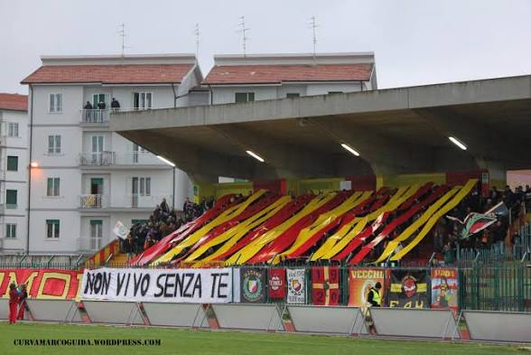Tifosi giallorossi sotto la tribuna con bandiere e nastri giallorossi